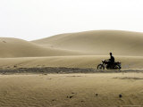 Man Riding Through Karakum Desert on Motorcycle