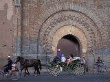 Horse-drawn wagon with passengers pass city gate