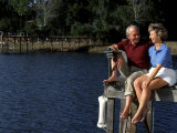Healthy Couple Sitting on the Dock by a Lake