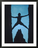 Silhouette of rock climber between two rocks