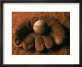 Baseball glove with ball on dirt