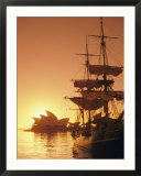 Sydney Opera House and the HMS Bounty  a replica of the famous ship  silhouetted by the setting sun