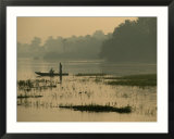 Fishermen drift along the bank of the Nile as twilight falls