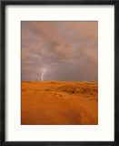 A bolt of lightning strikes the sand dune landscape