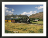 Old Locomotive with Billowing Black Smoke in Hilly Countryside