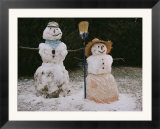 A pair of cheerful snow-people dressed with hats  scarf  apron  and broom