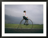 A man pedals an old-fashioned bicycle ahead of an Indiana thunderstorm