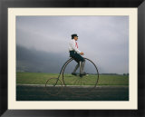 A man pedals an old-fashioned bicycle ahead of an Indiana thunderstorm