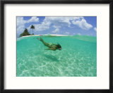 A woman snorkels in the clear blue sea