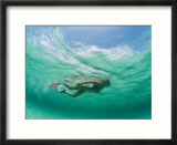 A woman snorkels under the waves