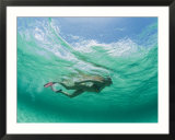 A woman snorkels under the waves