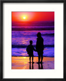 Sunset Silhouette Of Mom And Boy Along Coast