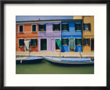 A view of the brightly colored buildings of Burano with gondolas floating at their doorsteps