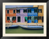 A view of the brightly colored buildings of Burano with gondolas floating at their doorsteps