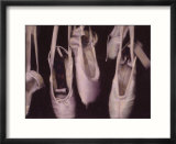 Worn ballet shoes hanging in a window