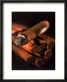 Lit cigar on top of bundle of cigars