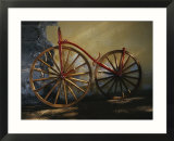 An antique bicycle rests against a wall