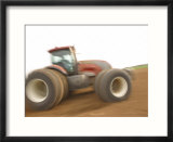 A Blurry Tractor Moving with Speed in a Brown Field
