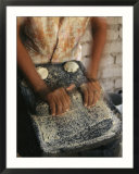 A Cora woman grinds corn for tortillas