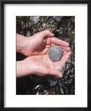 Person Holding Rock with the Word Blessings in Rushing Water