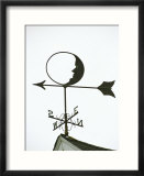 A Man-In-The-Moon Weather Vane on a Roof Top