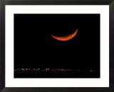 A Crescent Moon Dwarfs the Lights of Fort Riley Army Base in Central Kansas  January 22  2007