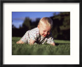 A Baby Boy Crawls Through the Green Grass