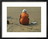 A Chinese Person Rests on a Street Curb after Sweeping the Sidewalk