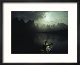 A Fisherman Poles His Raft Past Karst Formations on the Li River