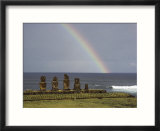 A rainbow arches above statues carved from volcanic rock