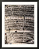People enjoy the view from the ancient stone seats of a Roman amphitheater