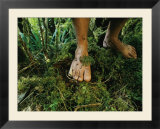 Close view of bare feet on moss-covered soil