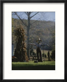 A scarecrow stands guard next to a corn shock