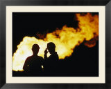 Natural gas workers silhouetted by burning dross