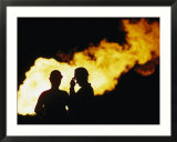 Natural gas workers silhouetted by burning dross
