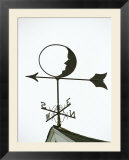 A Man-In-The-Moon Weather Vane on a Roof Top