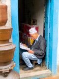 Hindu Man Reading Paper in Doorway of Bhaktapur  Kathmandu  Nepal