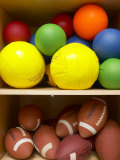 Colorful Balls and Footballs Arranged on Shelves of Wooden Storage Closet
