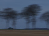 Motion Blur of Speeding Car on Tree-Lined Road in France