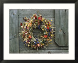 A delicate dried flower wreath adorns a wooden wall near a window