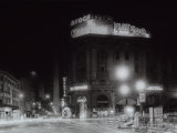 Night City View with Neon Signs of the New Fiat 500 Located on the Roof of a Building