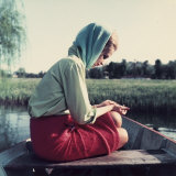 Young Woman Sitting on a Boat in a Thoughtful Pose