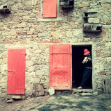 Woman with a Rabbit in Her Arms Leaning on the Jamb of a Door in a Stone Farmhouse