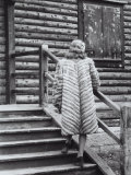 Model Posing on the Steps of a Mountain Chalet Wearing a Light Colored Fur with Dark Stripes