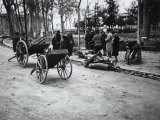 Group of People Next to an Old Woman Weighing Pieces of Wood on a Scale