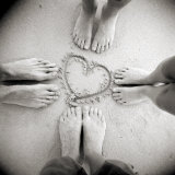 Four Pairs of Feet Standing around a Heart Shape Drawn in Sandy Beach  Taransay  Scotand  UK
