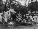 Three Sumo Wrestlers Posed Outdoors with Spectators in Background  Probably in Japan  1905