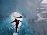 A hiker explores an ice cave recently revealed at Mendenhall Glacier