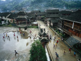 Village children play in the wet school yard following a downpour
