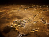Lights of Chicago burn brightly at night under a blanket of clouds